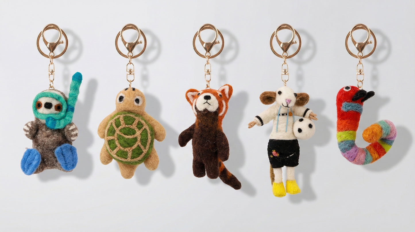 Five handmade Nepal wool felt animal keychains showing otter turtle red panda sheep and caterpillar