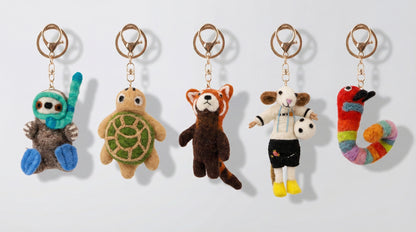 Five handmade Nepal wool felt animal keychains showing otter turtle red panda sheep and caterpillar