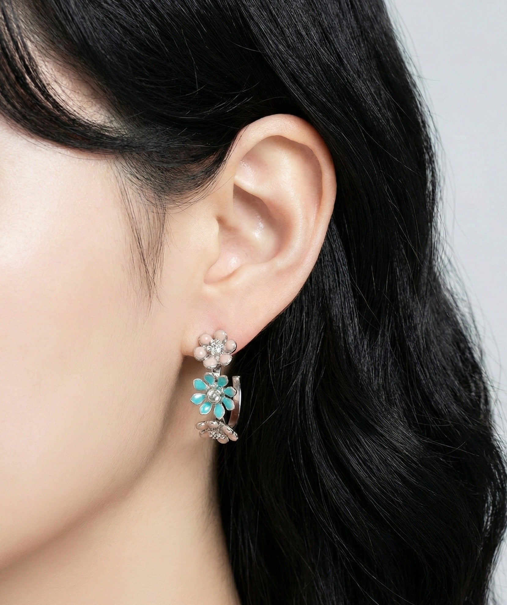 Model wearing mint garden enamel flower hoop earrings side view showing earring placement
