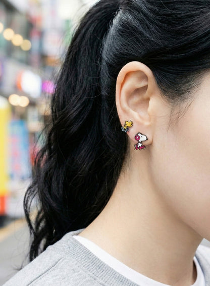 Street style photo of woman wearing Snoopy roller skate two-way earrings with Woodstock stud