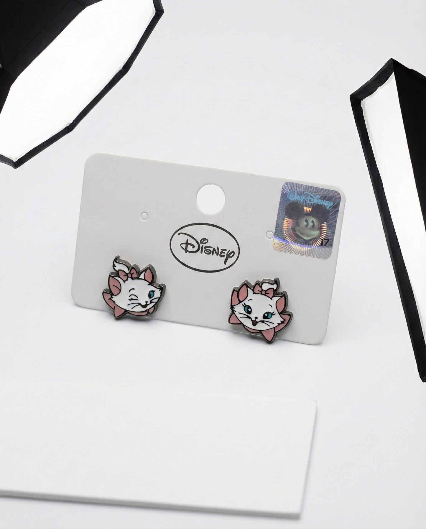 Marie cat face earrings on white card showing enamel detail and silver posts