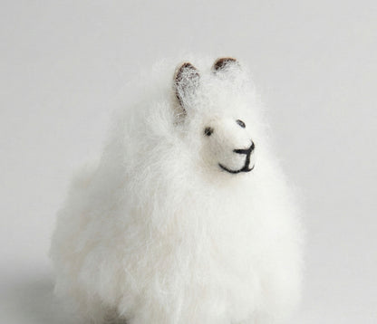 Close-up of white alpaca keychain showing detailed embroidered face