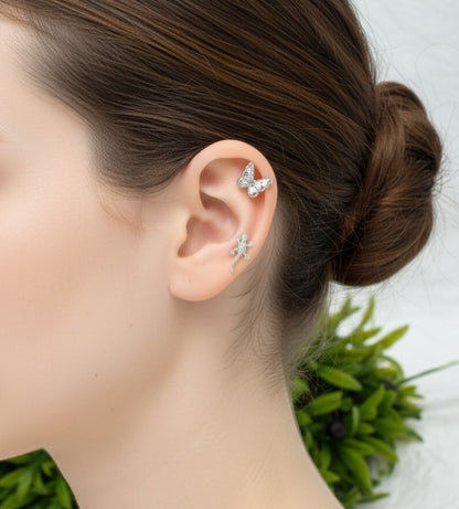 Close-up of an ear wearing butterfly-shaped earrings with a blurred background