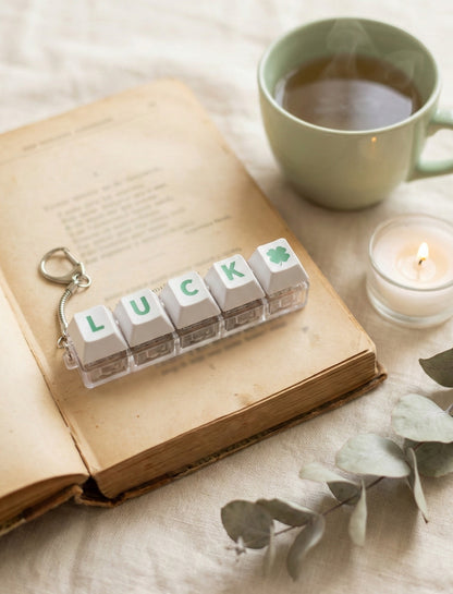 LUCK keychain on vintage book with candle and coffee for aesthetic flatlay photography