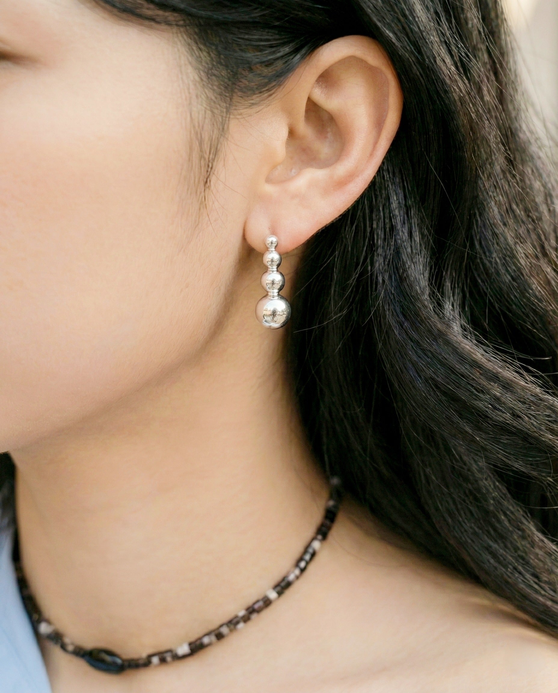 Silver 4-tier sphere bar earrings with off-shoulder blue blouse and beaded necklace