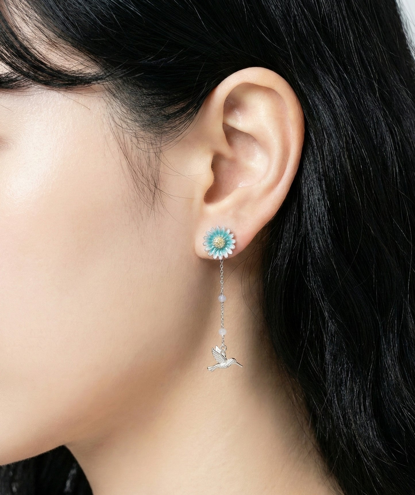 Side angle of model wearing silver earrings showing chain detail