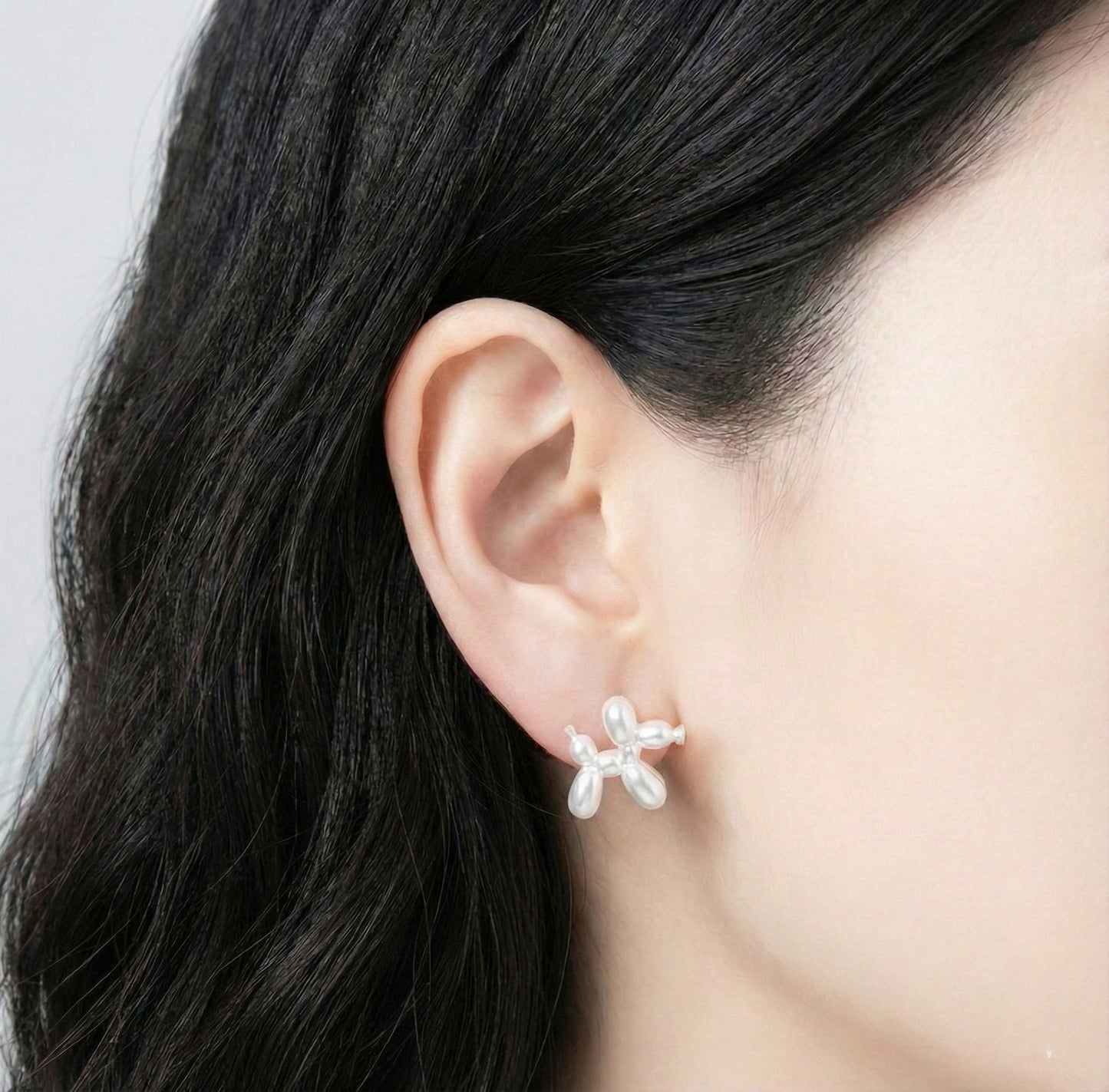 Model wearing pearl white balloon dog earring showing elegant minimalist look