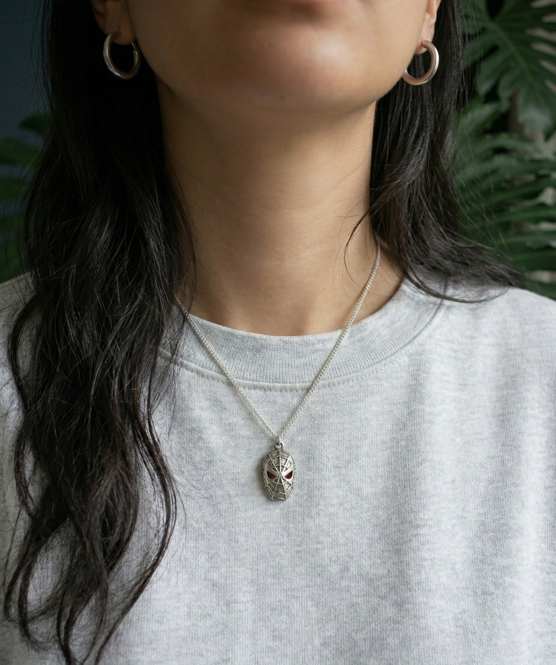 Woman wearing a unique 925 silver spider pendant with a casual grey sweatshirt