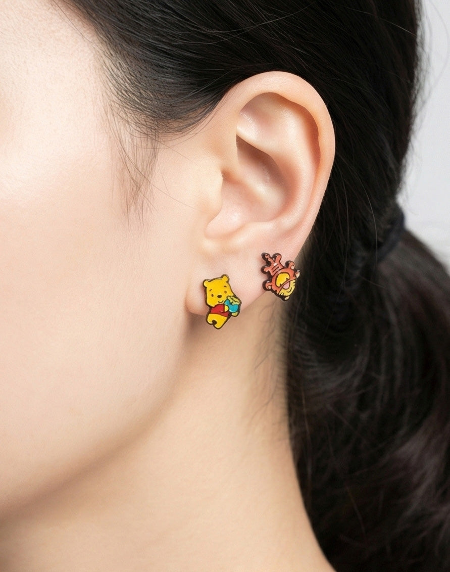 Side view of Winnie the Pooh honey pot and bouncing Tigger asymmetrical earrings on ear
