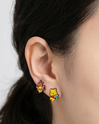 Close-up of Disney Tigger and Pooh earrings worn showing vibrant enamel coloring and detail