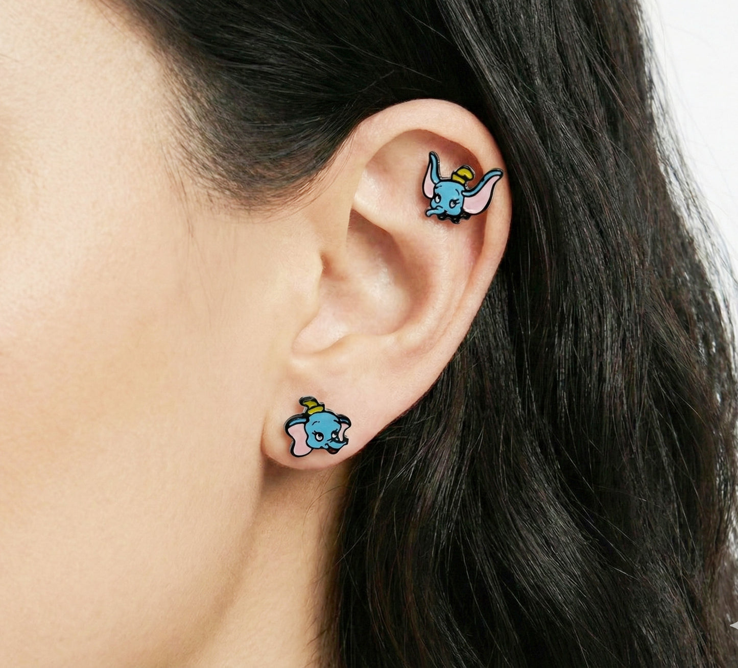 Woman wearing baby elephant piercings on lobe and helix - kawaii character ear curation