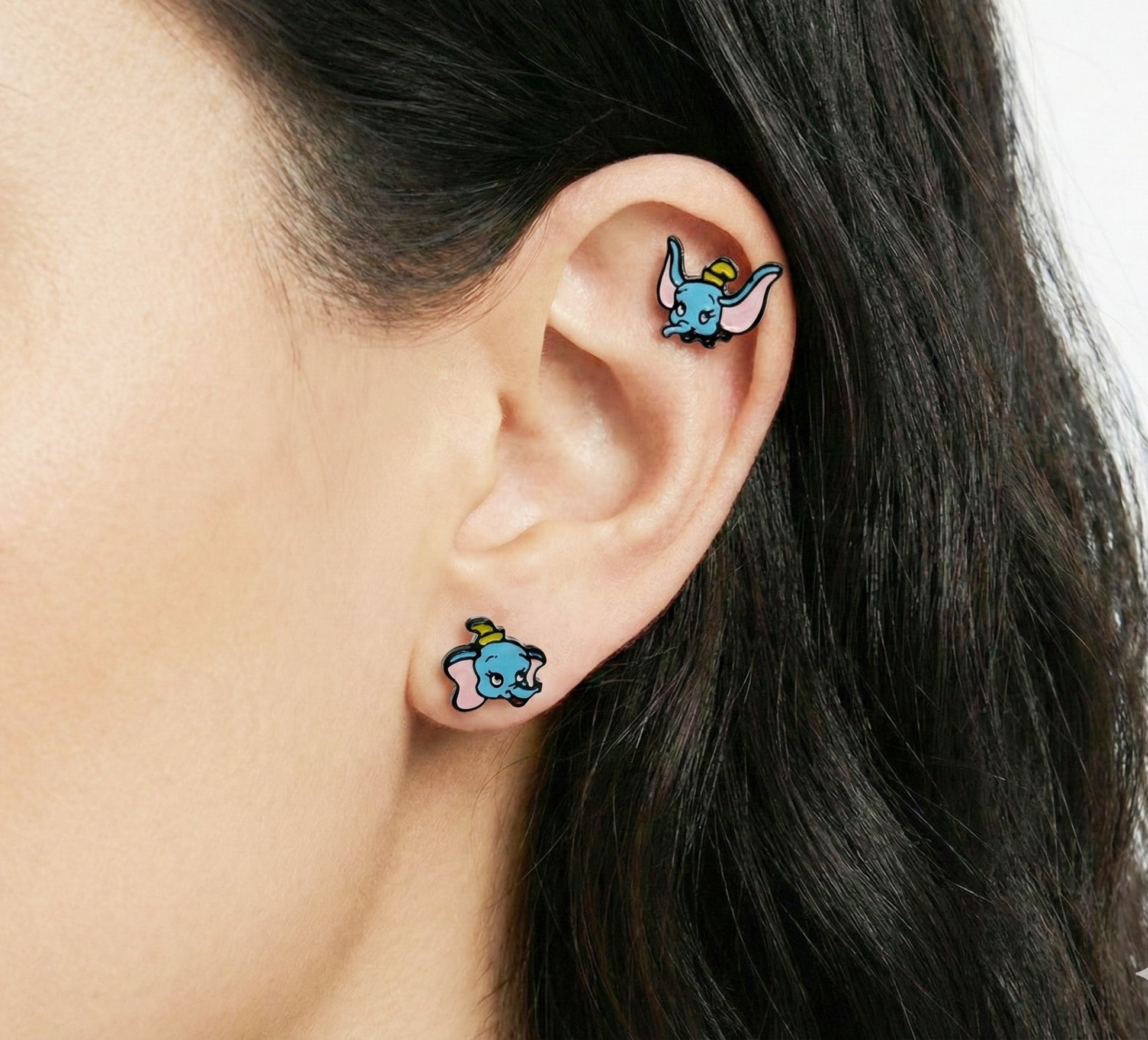 Woman wearing baby elephant piercings on lobe and helix - kawaii character ear curation