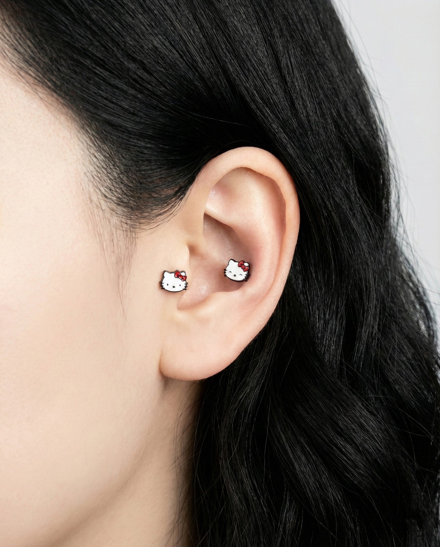 Hello Kitty barbell studs worn in inner conch and lobe piercing ear stack