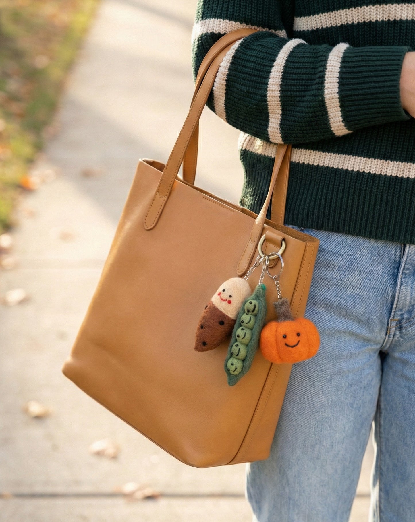 Wool felt veggie keychains on tan leather tote bag outdoor