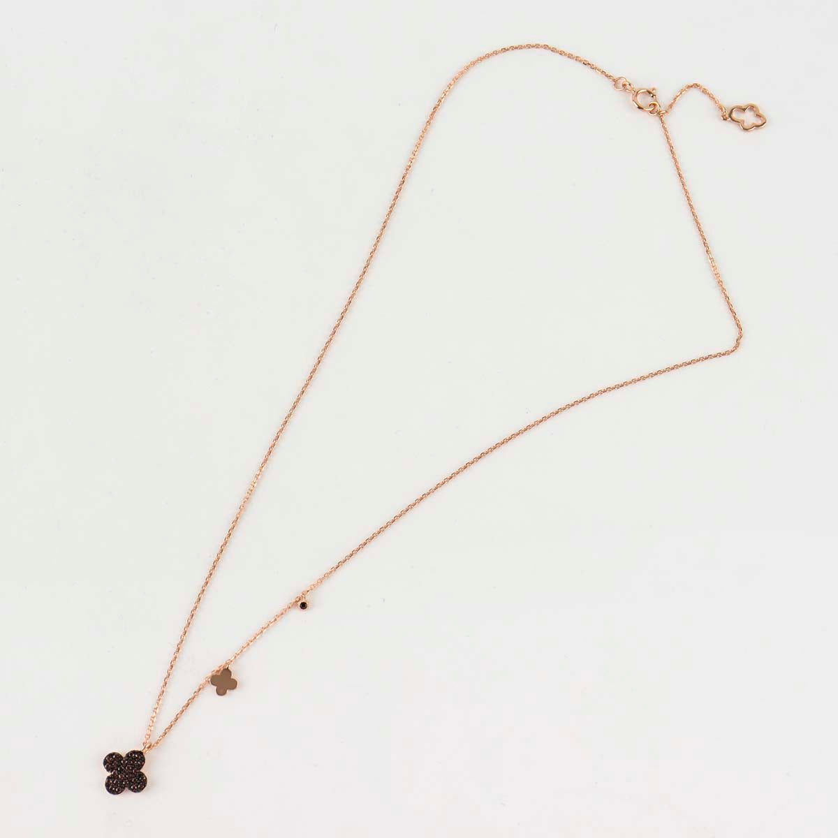 Full length flat lay of rose gold plated 925 silver clover necklace showing extender chain with clover-shaped clasp