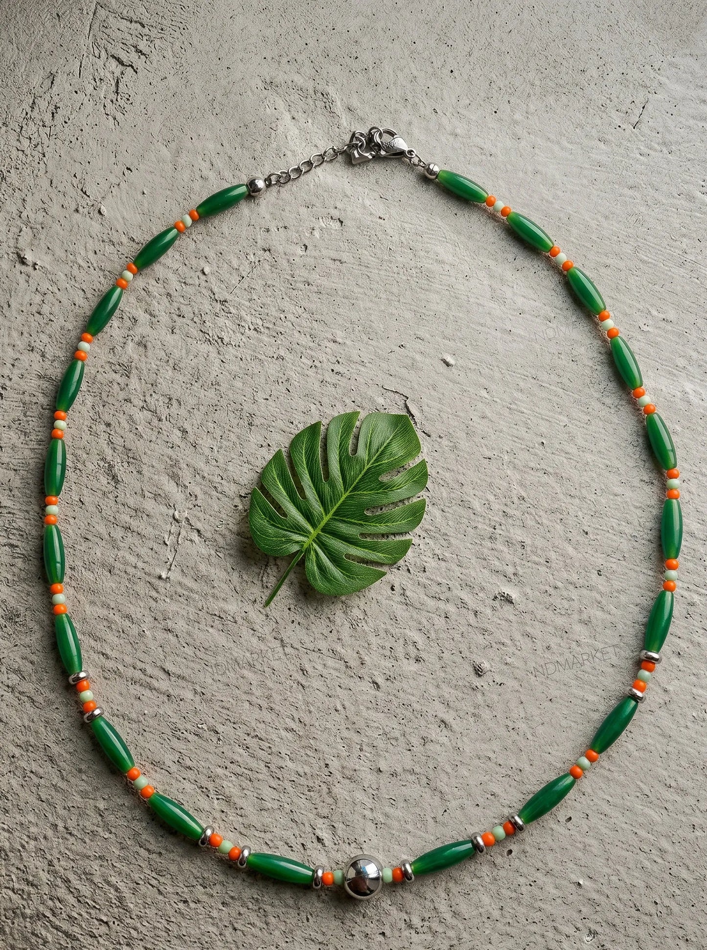 Botanical green single-strand beaded necklace with silver accent, resort wear aesthetic.