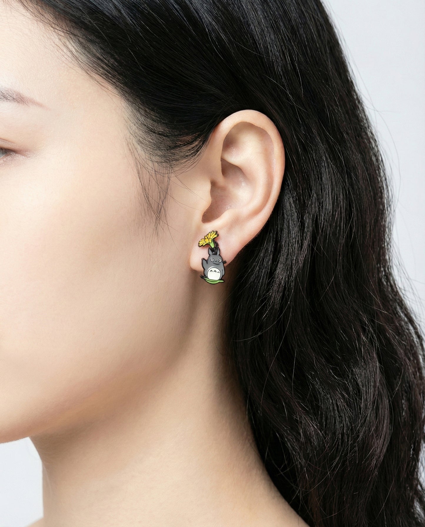 Woman wearing grey forest spirit front and back earring - front view