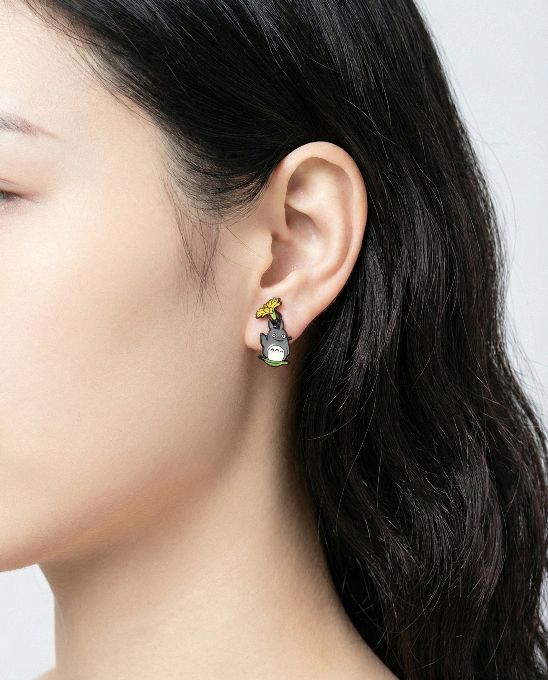 Woman wearing grey forest spirit front and back earring - front view