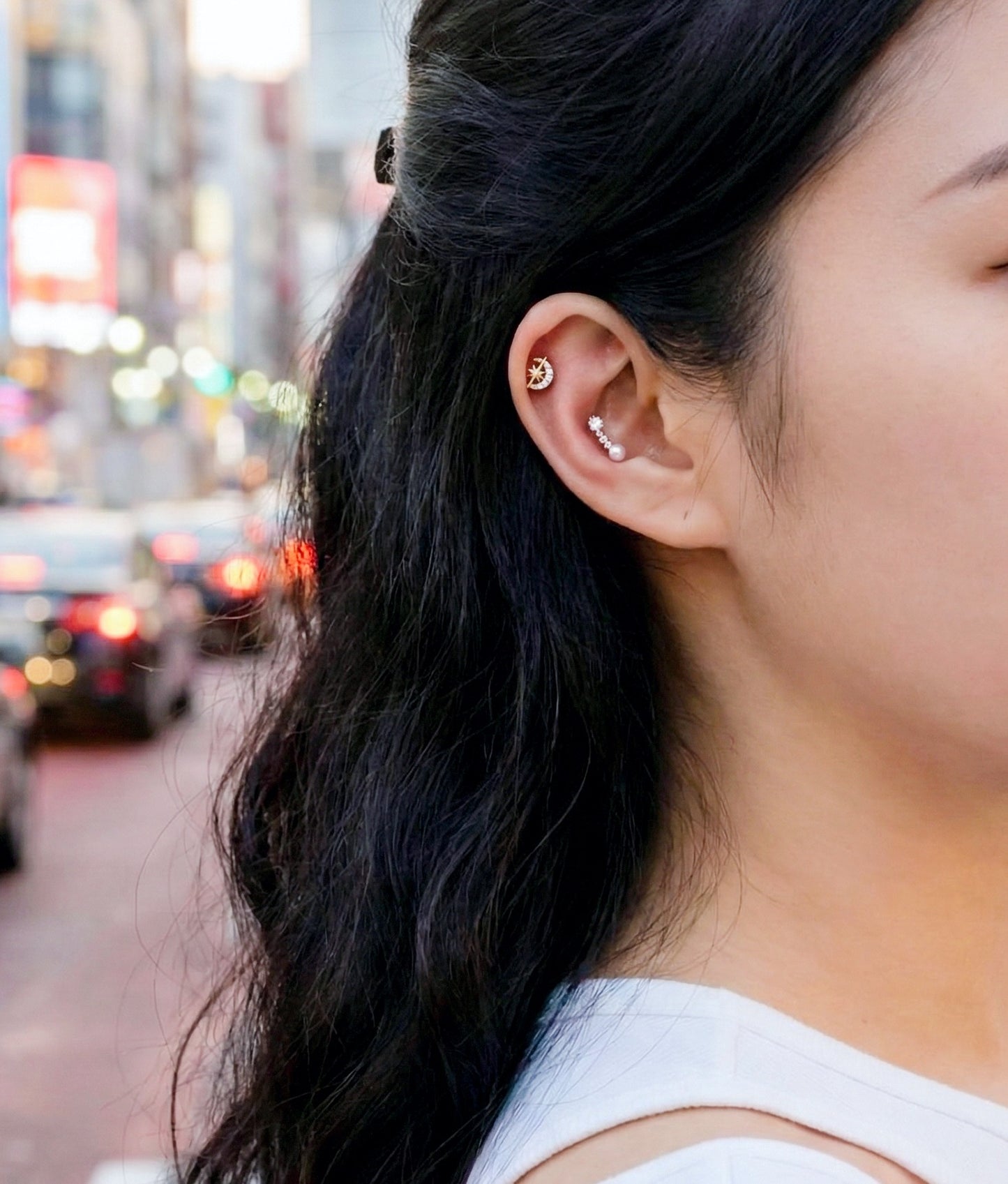 Ear curation with celestial moon piercing on helix and multiple studs, trendy piercing styling