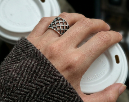 Lace lattice 925 sterling silver bold ring worn while holding coffee cup, herringbone wool coat sleeve, everyday styling, chunky silver ring detail