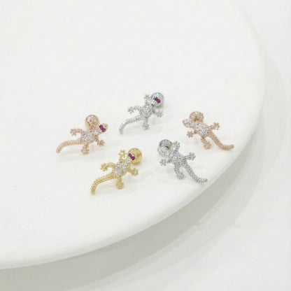 Five small animal-shaped earrings on a white plate