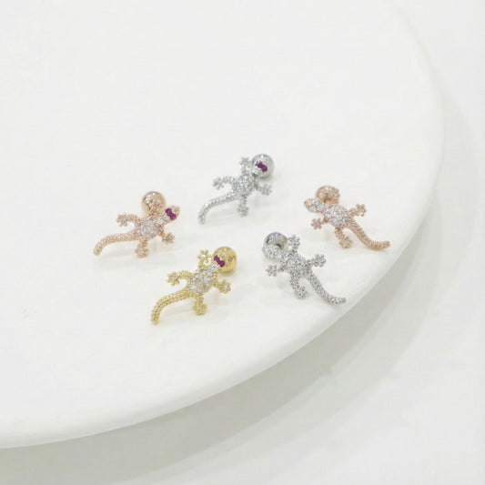 Five small animal-shaped earrings on a white plate