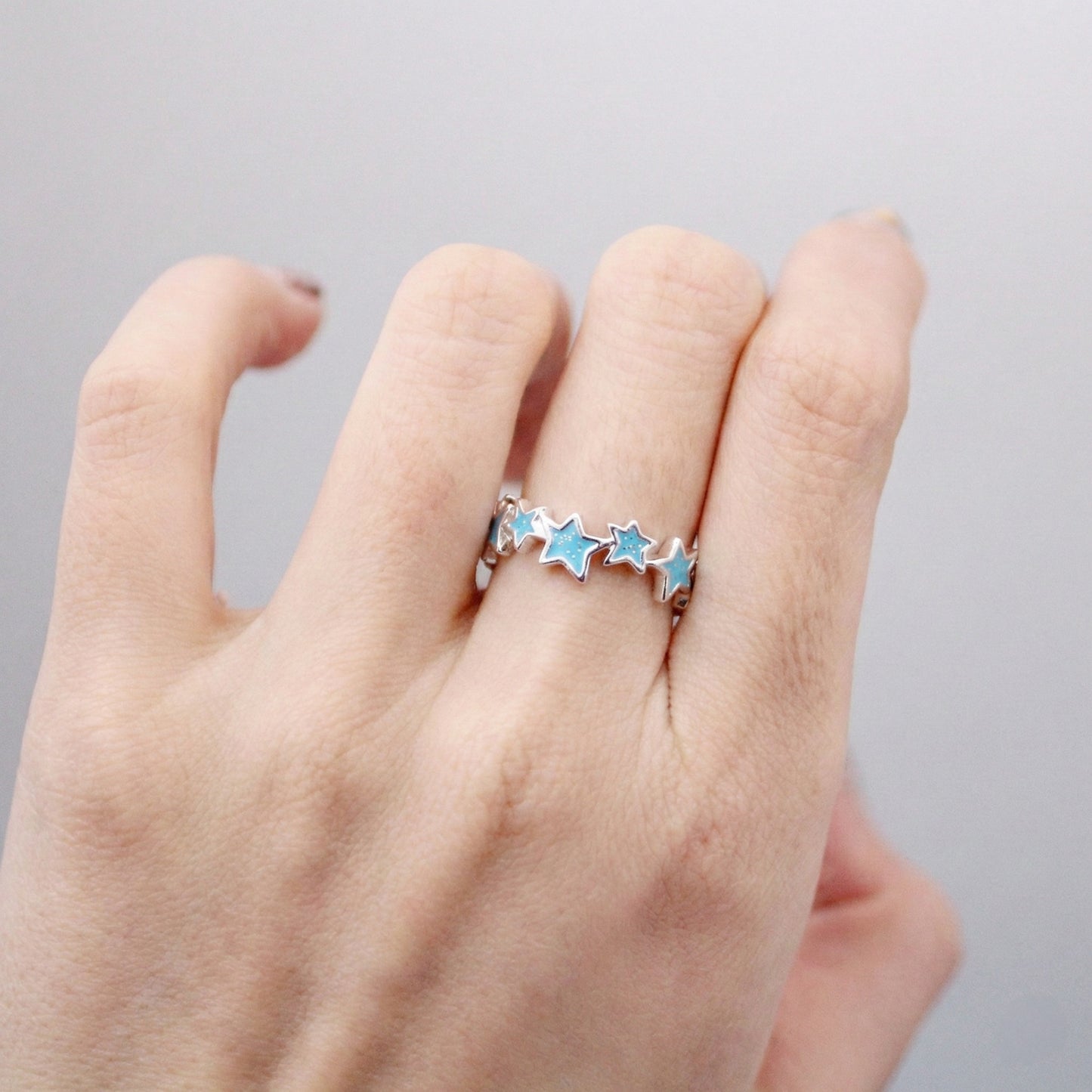 Sky blue enamel star ring worn casually demonstrating free size fit