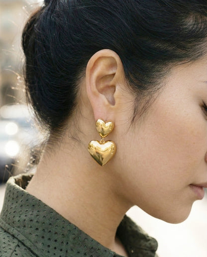 Gold chunky heart earrings with green textured jacket - street style close-up