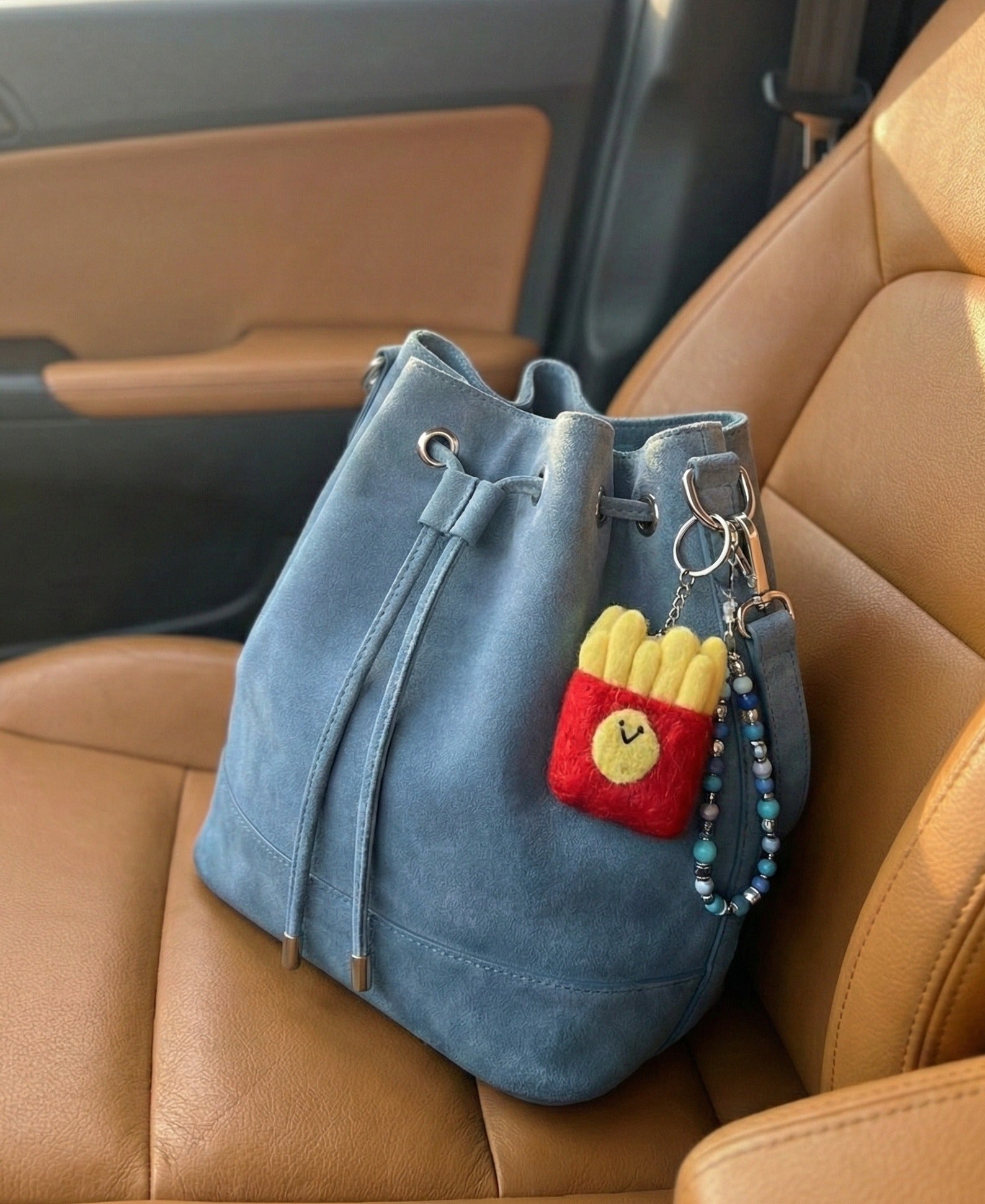 Happy fries wool felt keychain on blue suede bucket bag in car with beaded strap, travel accessory