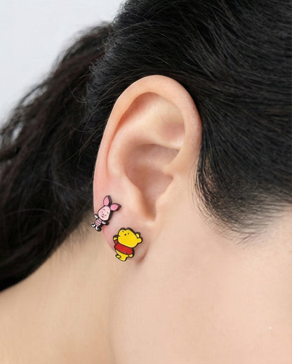 Woman wearing Disney Piglet and Pooh mismatched earrings, pink and yellow kawaii style jewelry