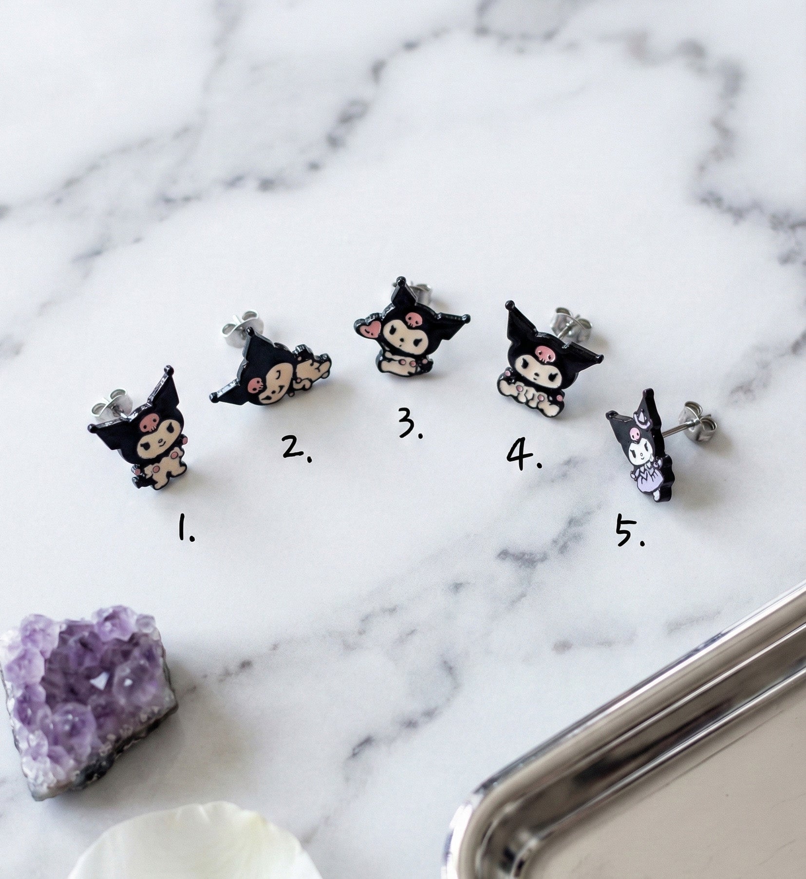  Five Kuromi enamel stud earring designs on marble showing numbered options 1 through 5