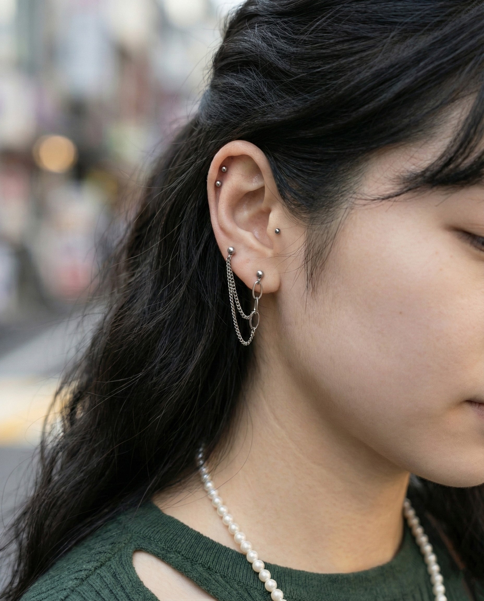 Double piercing chain earrings styled with pearl necklace showing versatile jewelry layering for Y2K aesthetic