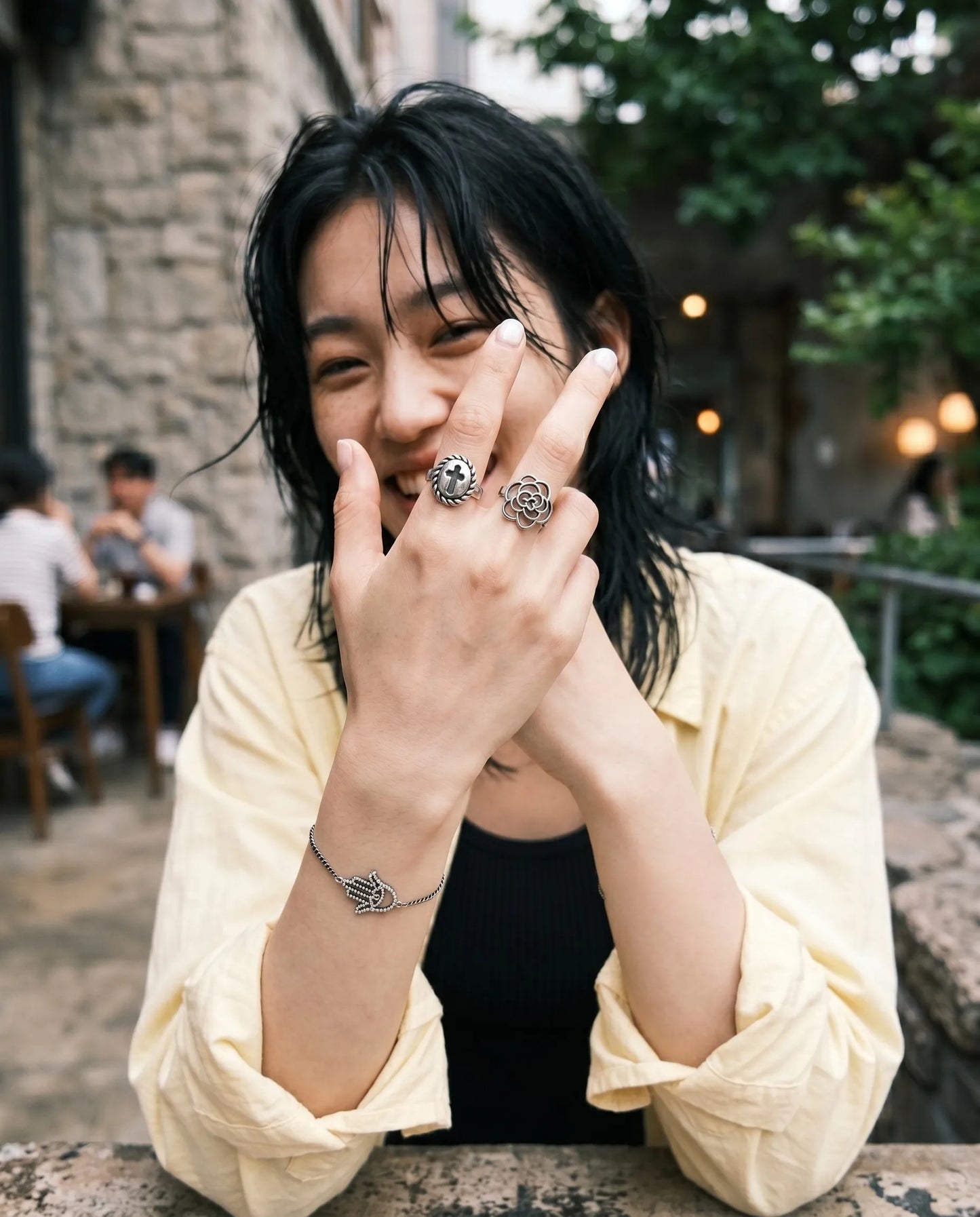 Smiling model wearing bold cross ring camellia ring with hamsa bracelet grunge floral layered ring stack 8ttitto8 K-style
