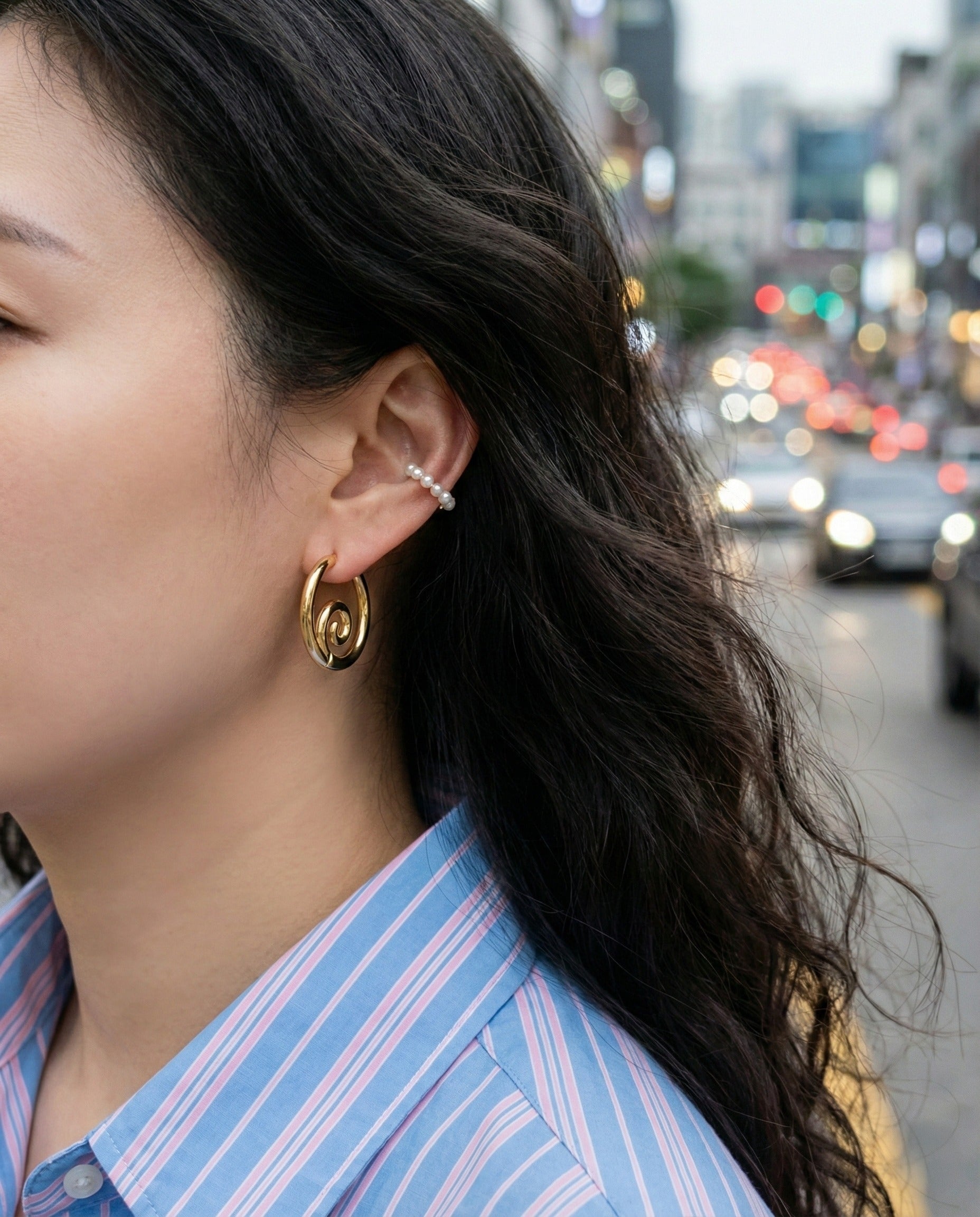 Gold clicker hoop earrings worn with blue striped button-down shirt - urban street style