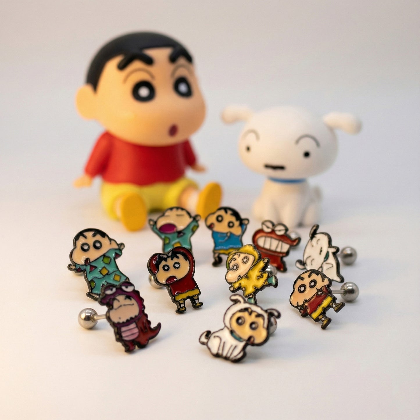 Complete set of 12 Shin-chan anime character earrings displayed with collectible figures