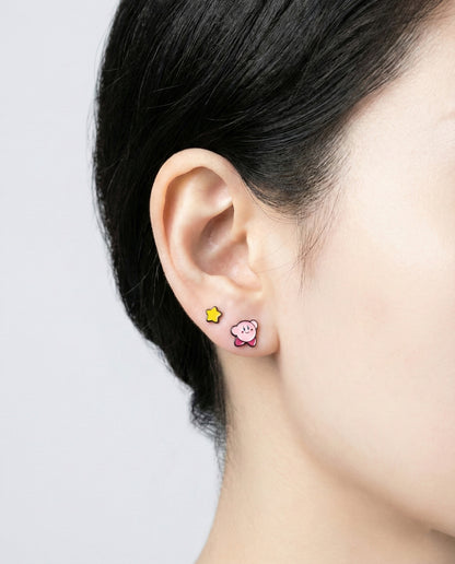 Kirby and star stud earrings worn on ear showing layered styling
