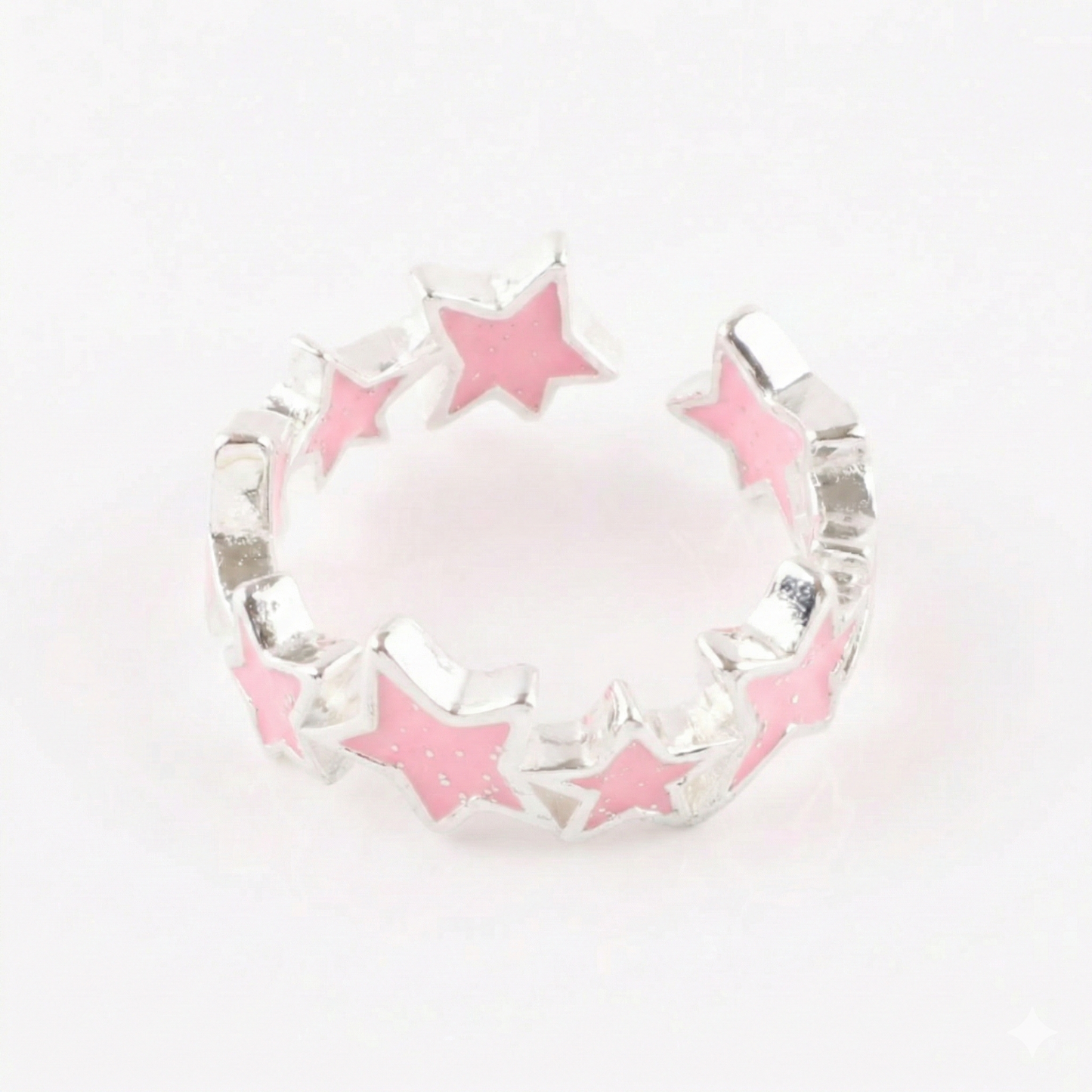 Baby pink sparkling star ring with glitter enamel on light wooden surface with book