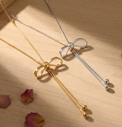 Gold and silver bow lariat necklaces side by side - adjustable Y-drop necklace options
