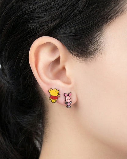 Angled view of Winnie the Pooh and Piglet character stud earrings with hypoallergenic silver posts
