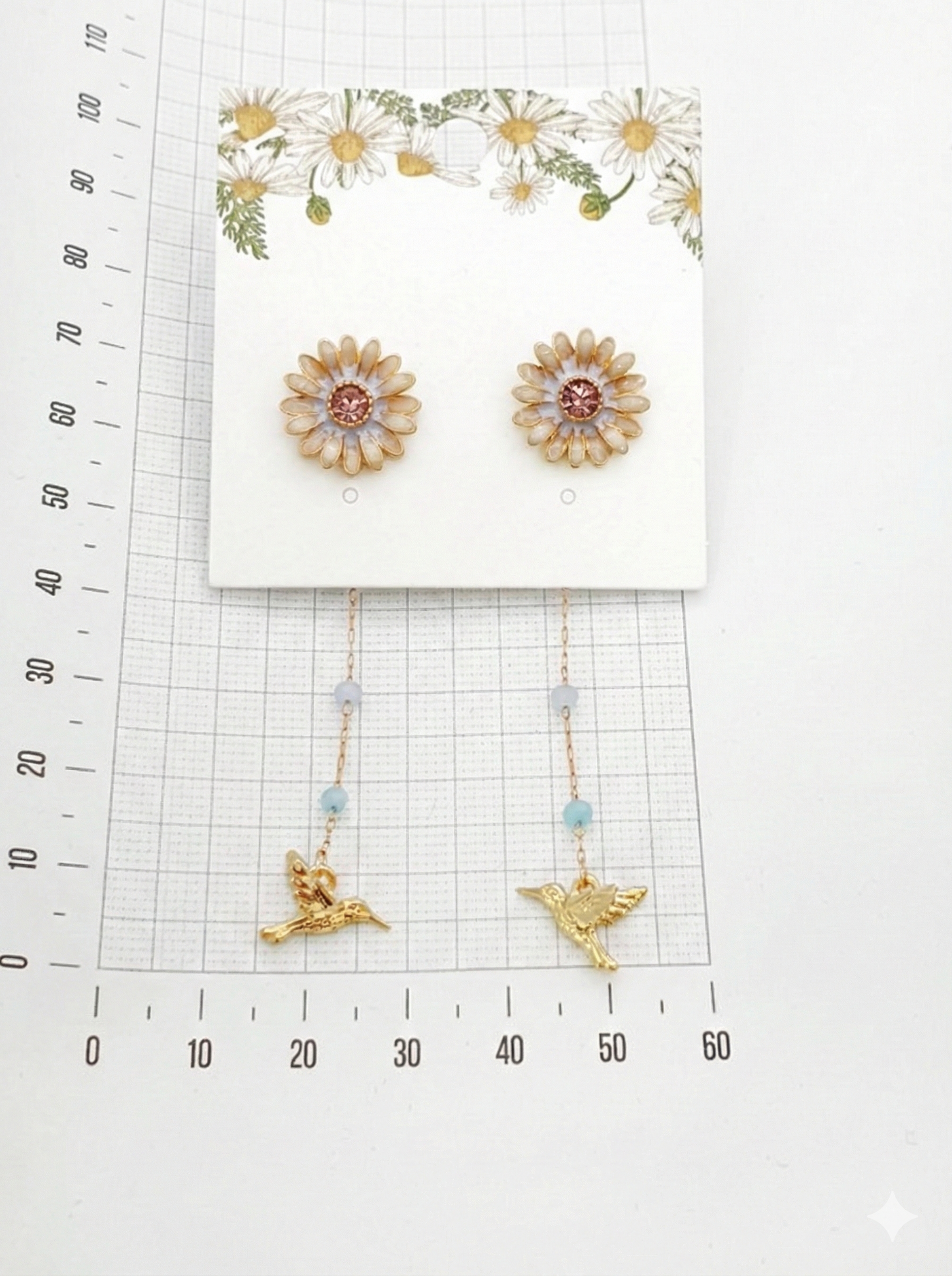 Measurement guide showing gold daisy earrings with ruler scale