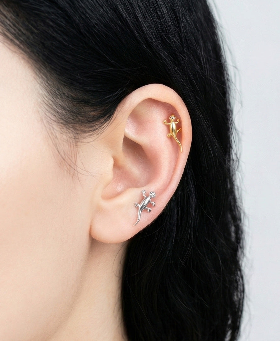 Gold gecko piercing worn on helix cartilage, unique animal jewelry styling on ear