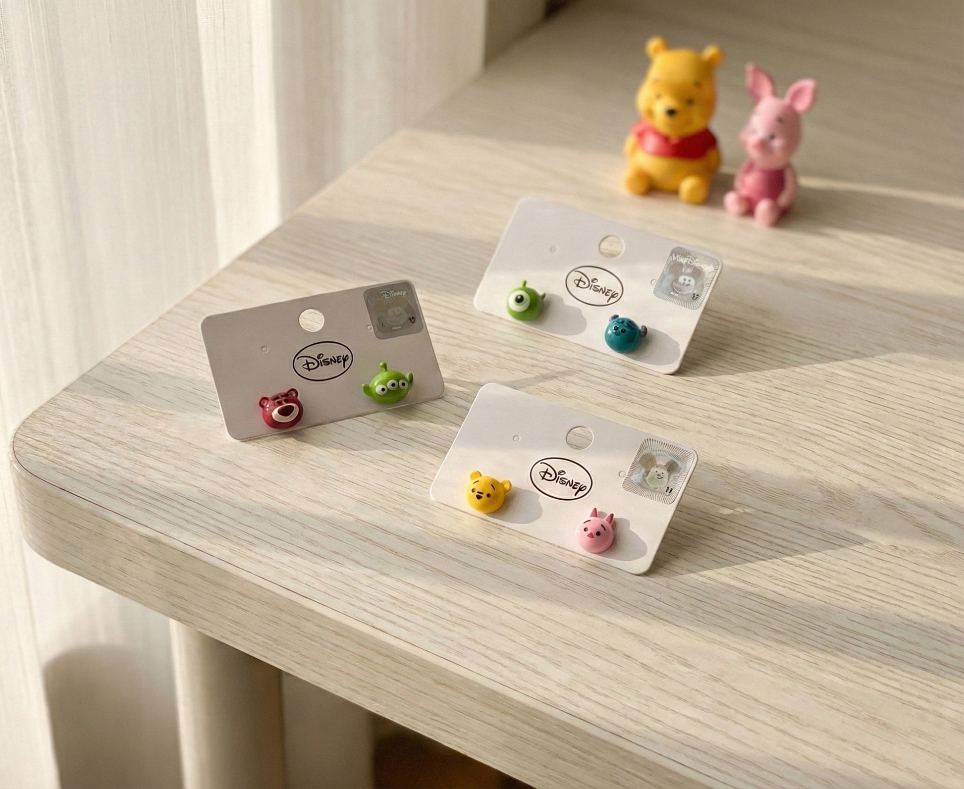 Disney Tsum Tsum earring sets flat lay with study desk and Winnie the Pooh figurines - kawaii lifestyle