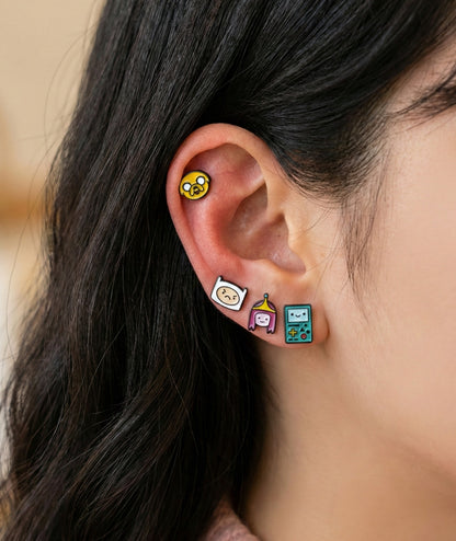 Close-up model wearing Adventure Time angry Finn and Princess Bubblegum mismatched earrings
