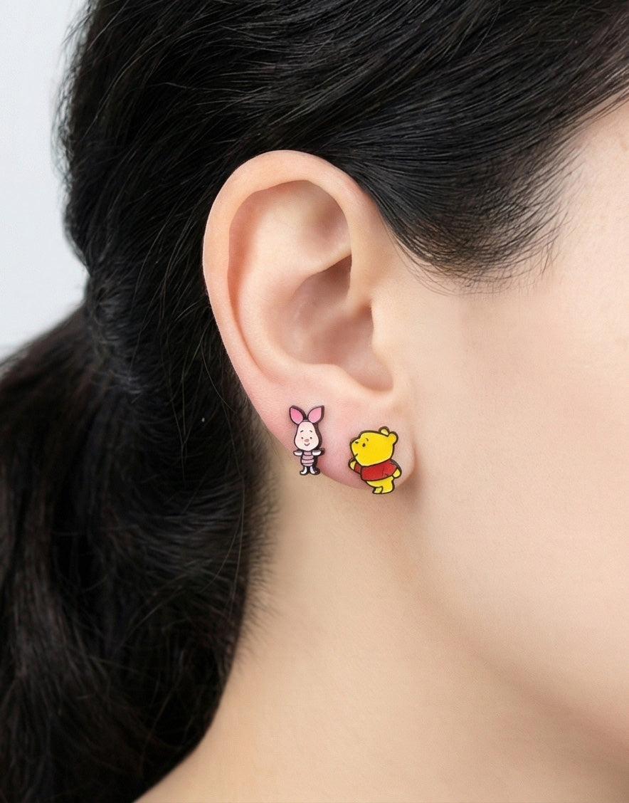 Disney Pooh and Piglet asymmetrical earrings on ear showing miniature character design detail