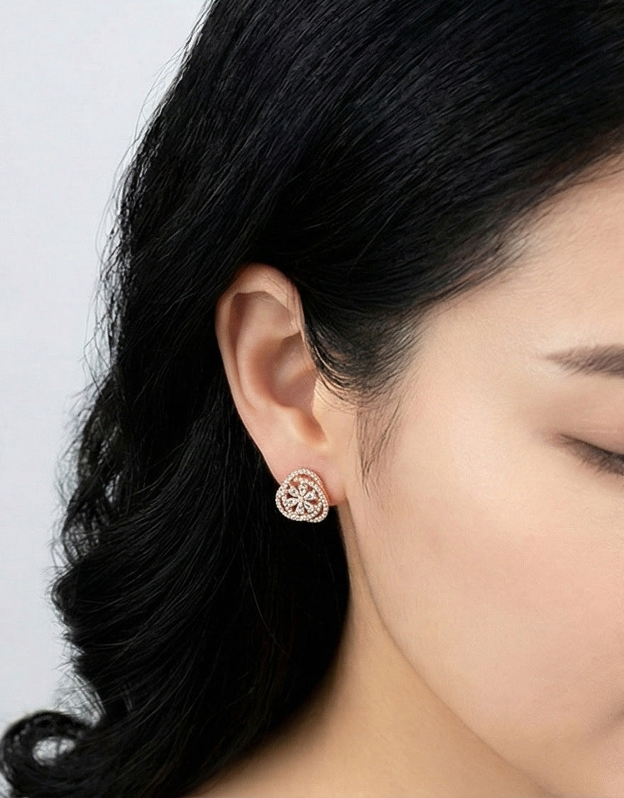 Front angled view woman wearing rose gold heart CZ stud earring showing flower detail, comfortable fit 925 silver posts, Korean elegant studs