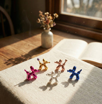 Close-up of pink balloon dog and heart earrings showing detailed layered styling