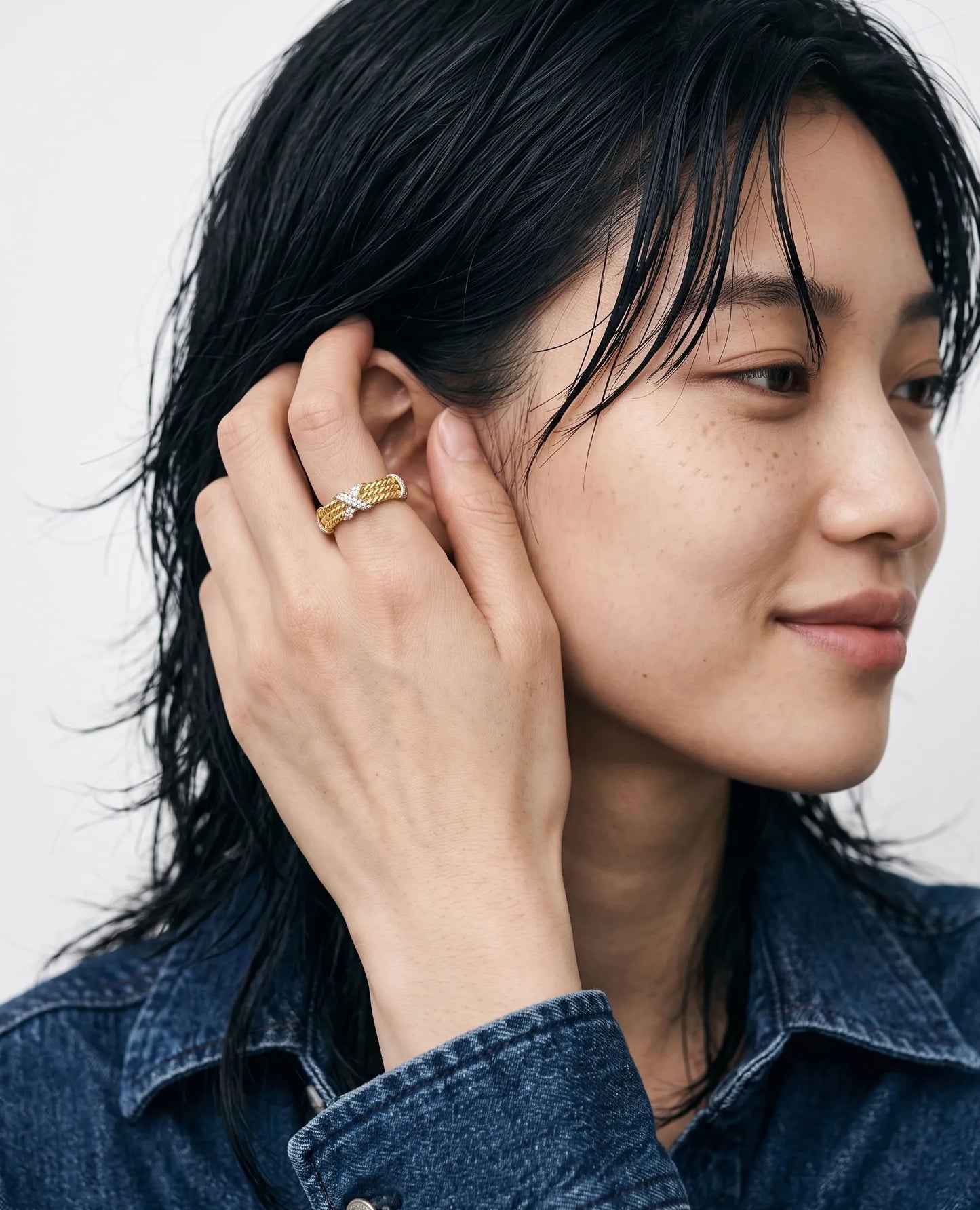 Clean girl aesthetic close-up portrait, two-tone cubic X ring styled with denim jacket.