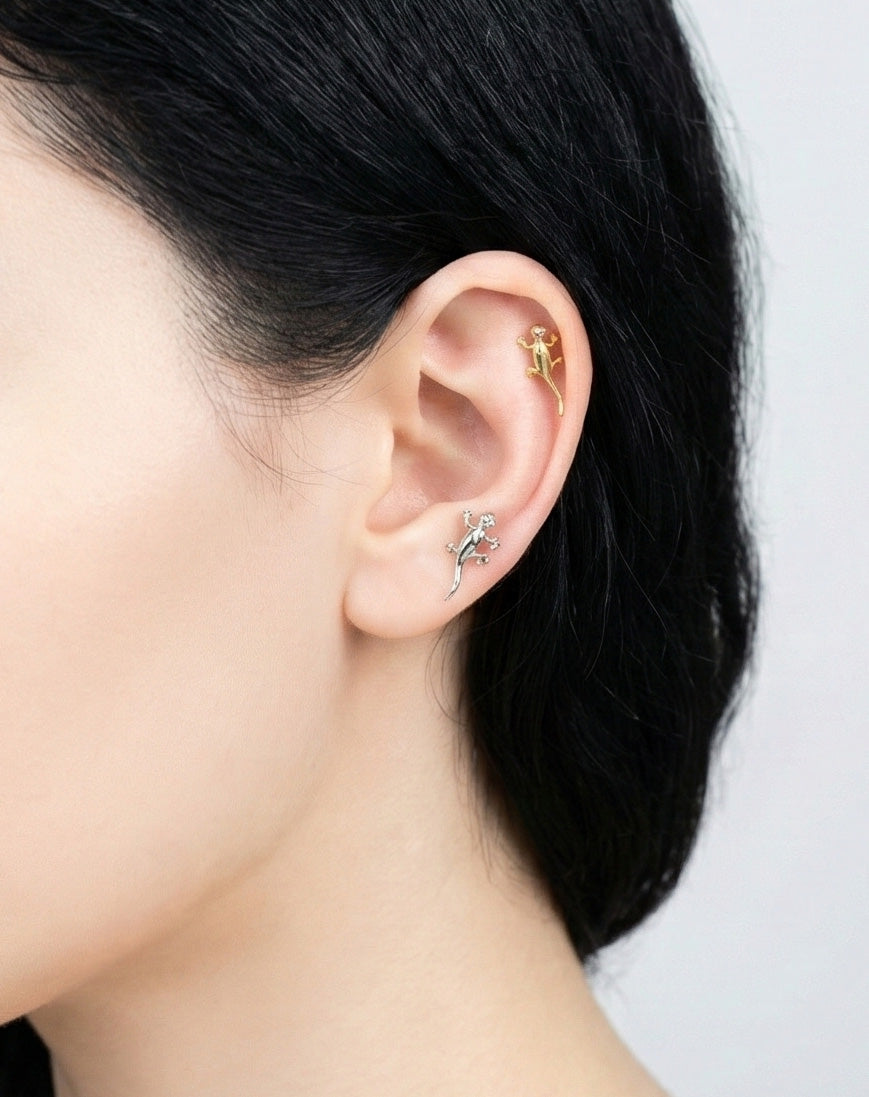 Gold gecko piercing worn on helix cartilage, unique animal jewelry styling on ear