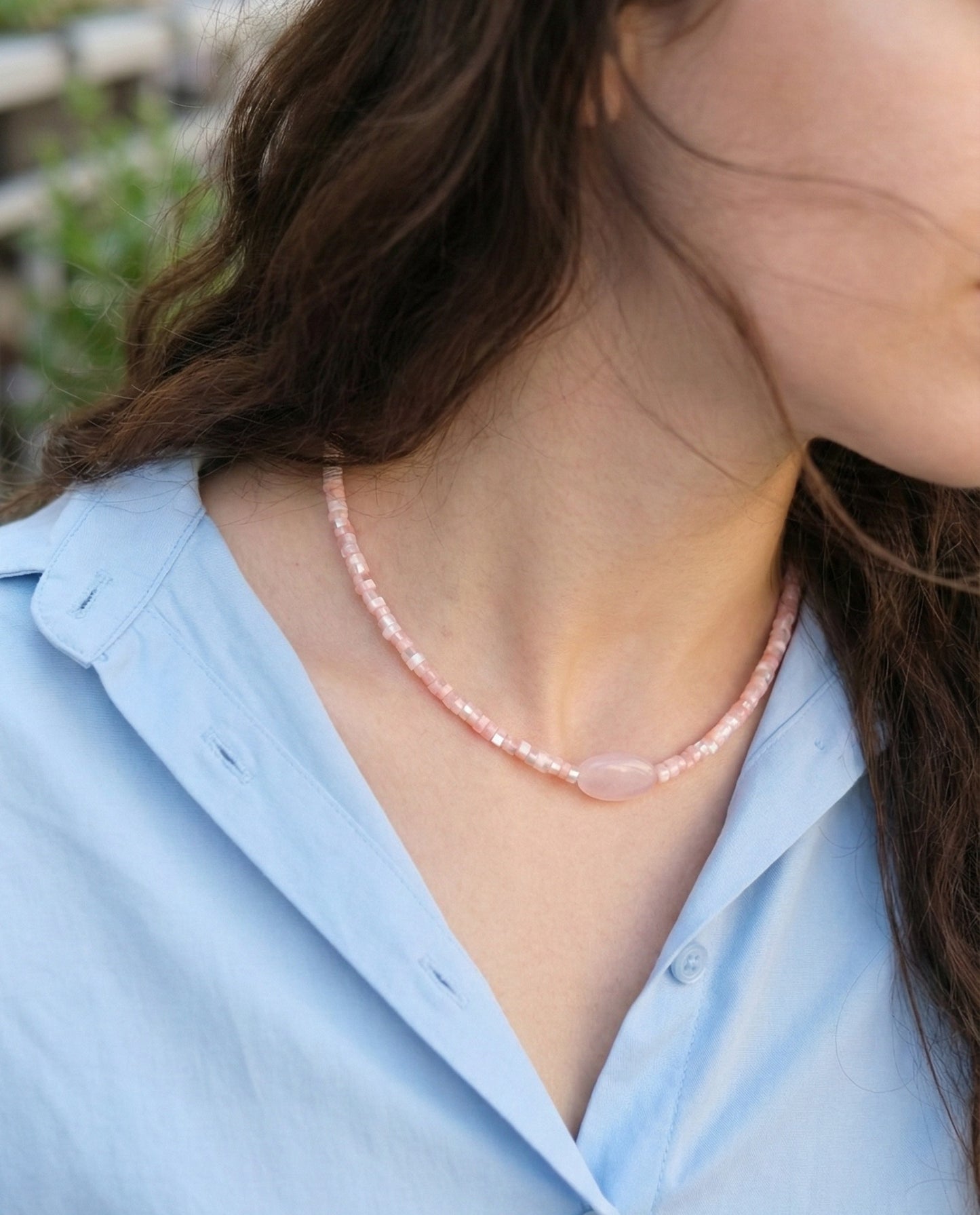 Woman wearing rose quartz pink choker with blue shirt, delicate and romantic look