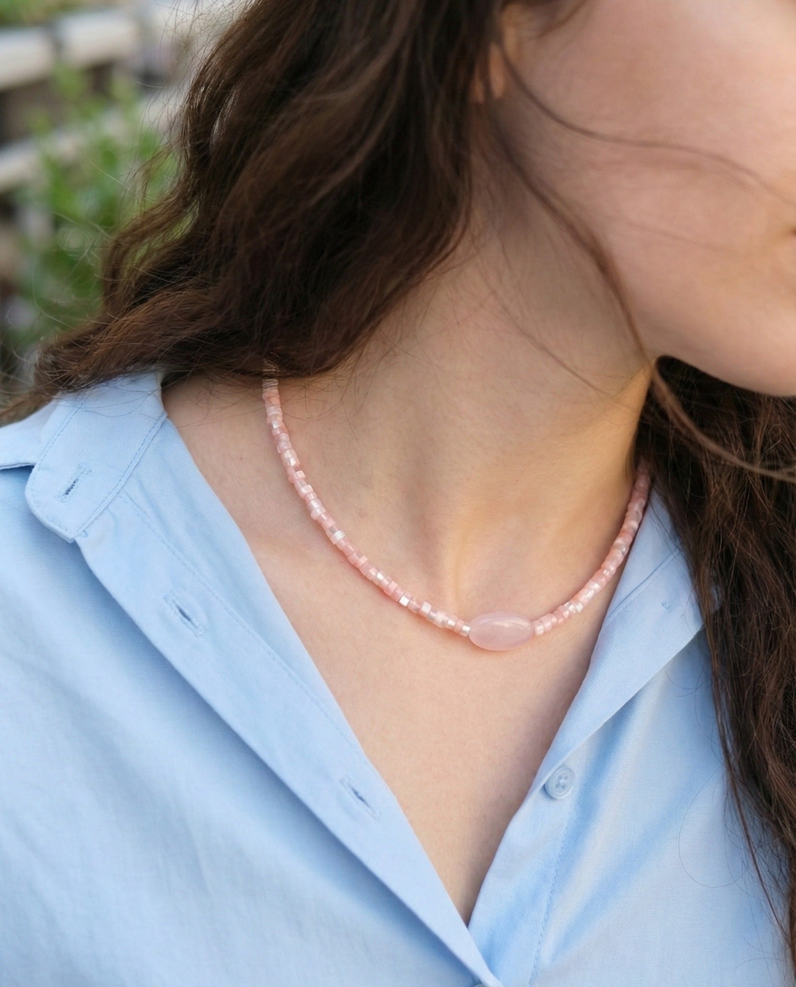 Woman wearing rose quartz pink choker with blue shirt, delicate and romantic look